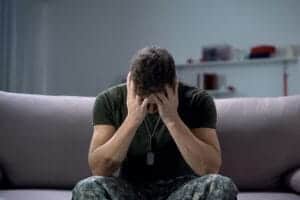 Man hides face and cries during PTSD treatment program